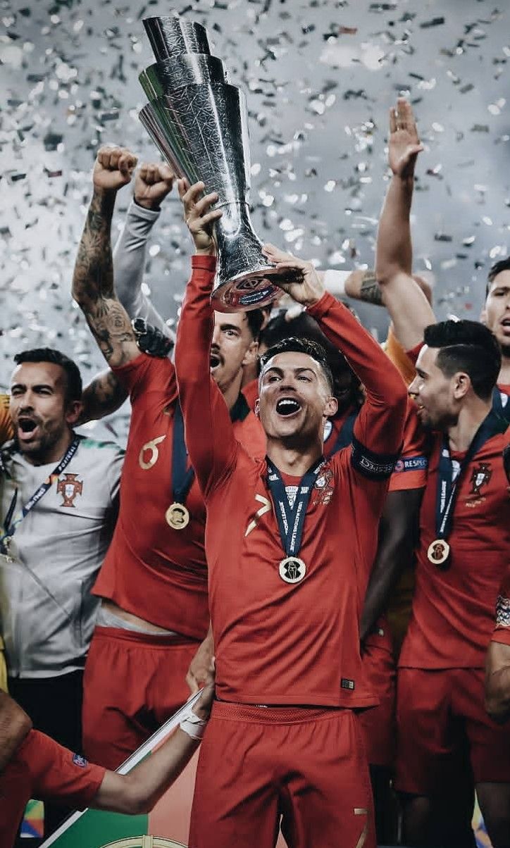 a group of men standing next to each other holding up trophy cups and confetti