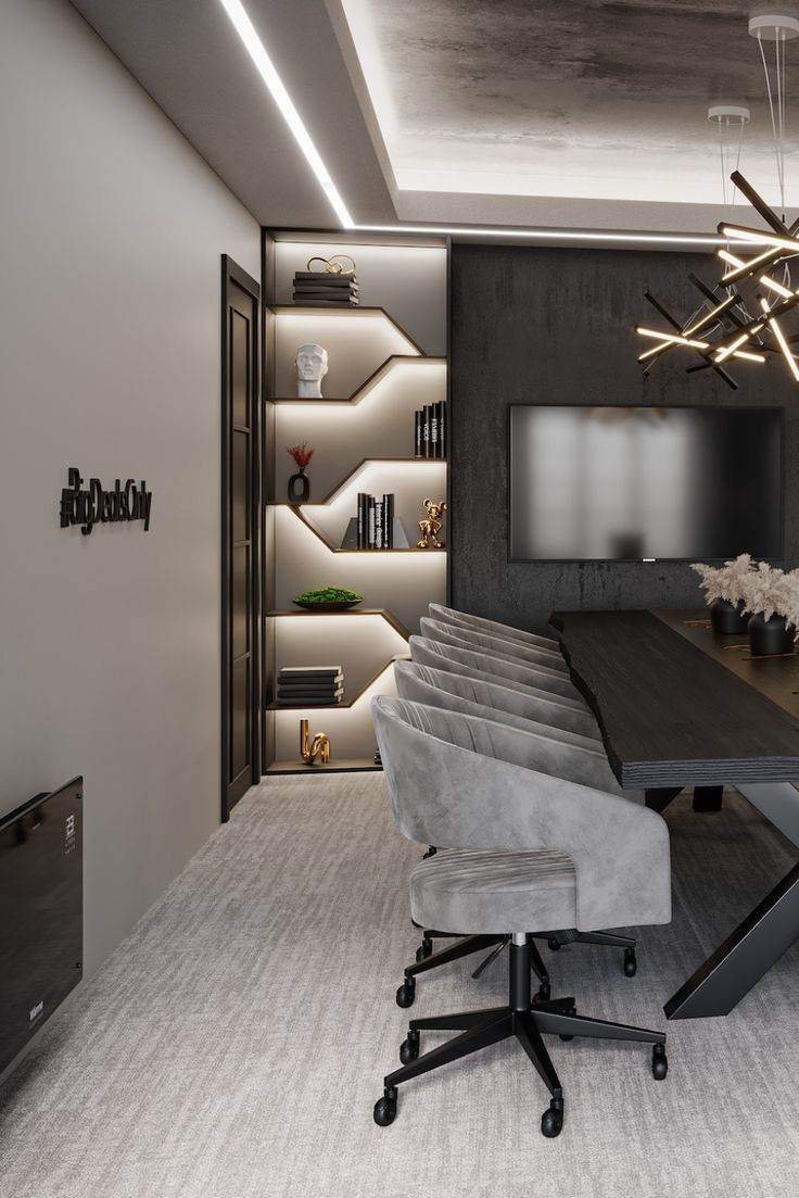 an office with a large wooden table and gray chairs in front of a wall mounted tv