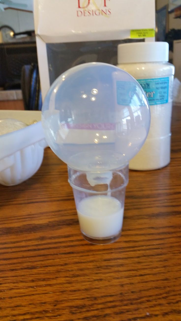 a plastic ball sitting on top of a wooden table next to some bottles and containers