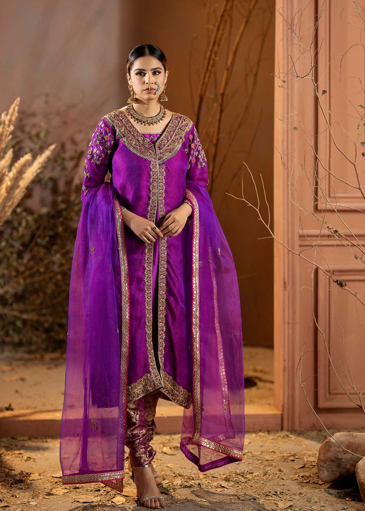 Introducing our stunning Purple Organza Outfit! This elegant dress is adorned with intricate details, featuring beautiful embroidery and embellishments. The rich purple color adds a regal touch, and it comes with a chooridar pajama for a complete look. Perfect for making a statement at special occasions! Bollywood Tissue Silk Dress With Dabka Detailing, Bollywood Style Dabka Embroidered Tissue Silk Dress, Elegant Jamawar Churidar For Designer Wear, Festive Dabka Tissue Silk Dress, Diwali Tissue Silk Dress With Dabka Embroidery, Semi-stitched Purple Anarkali Unstitched Suit, Elegant Semi-stitched Purple Sets, Purple Embroidered Unstitched Suit For Eid, Festive Purple Lawn Suit With Intricate Embroidery