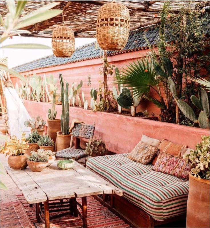 an outdoor seating area with potted plants and wicker lamps