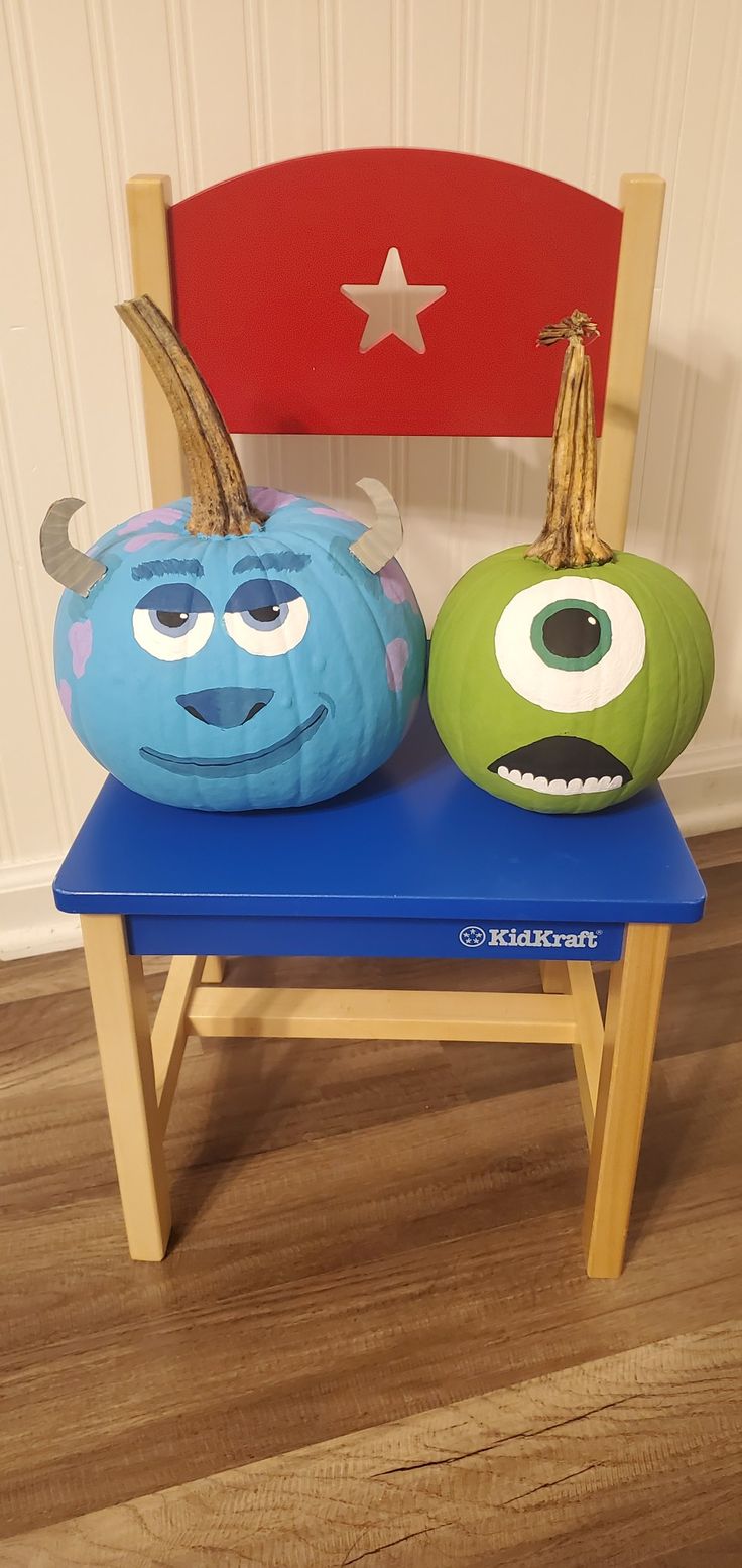 two monsters sitting on top of a blue chair