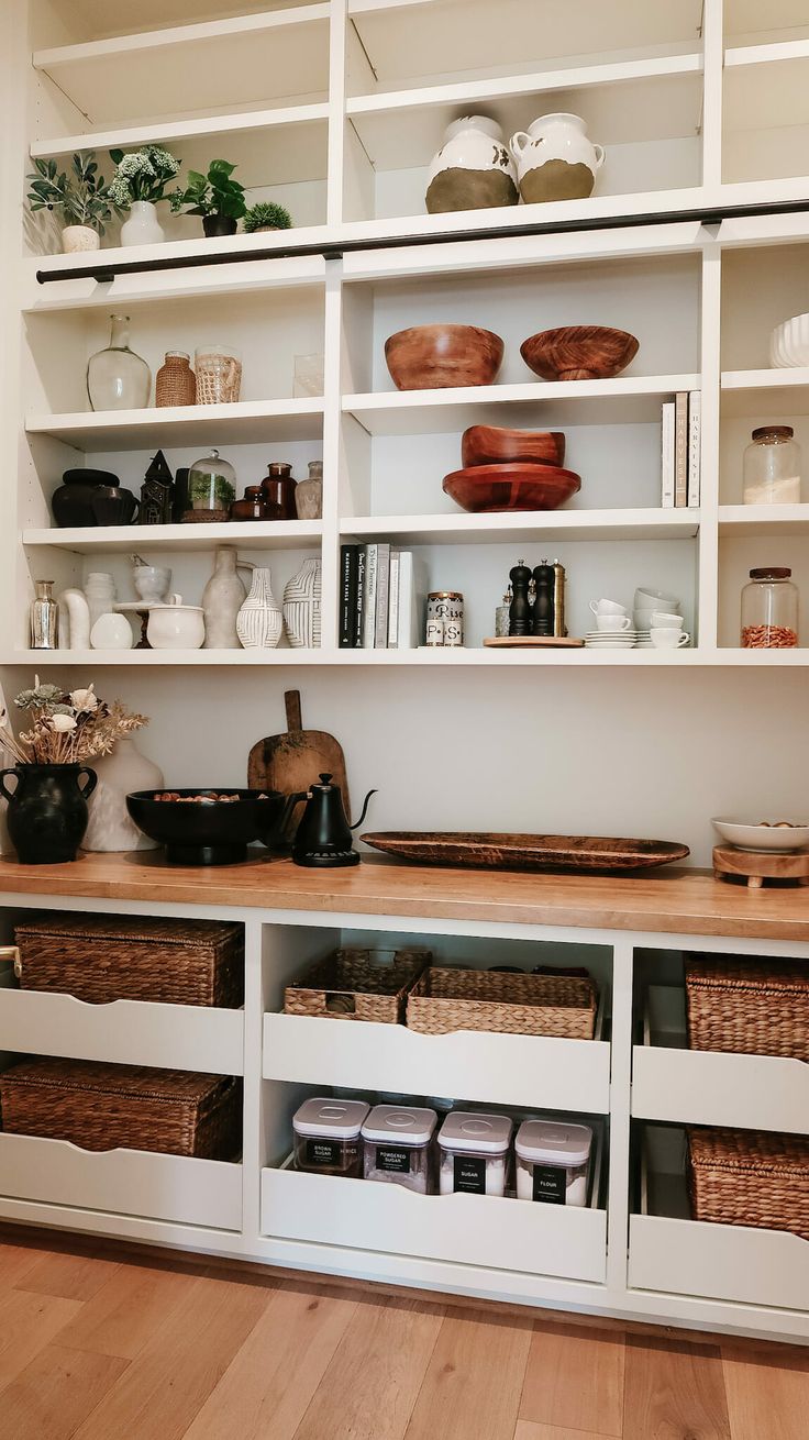 the shelves are filled with dishes and baskets on them, along with other kitchen utensils