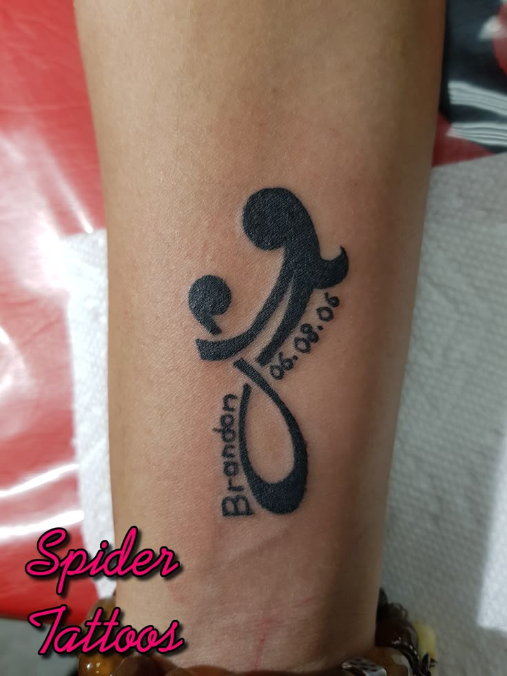 a spider tattoo on the leg of a woman's arm with an image of a spider