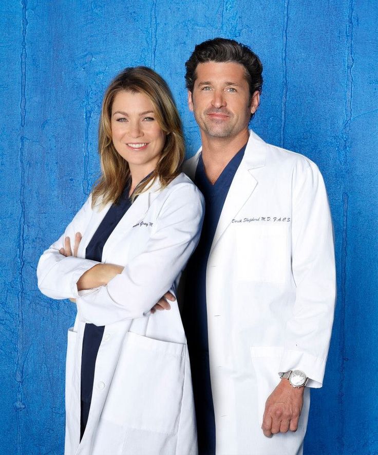 a man and woman standing next to each other in front of a blue wall with the words grey's anatomy on it