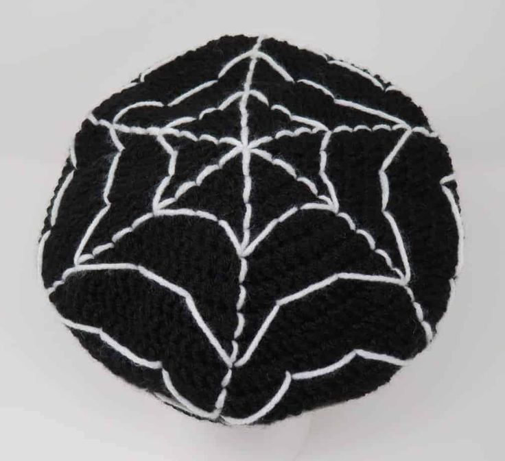 a black and white knitted hat with spider web