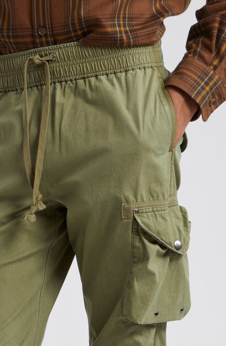 Relaxed-fit cargo pants are equipped with eight pockets, featuring grommets, rivets and snaps throughout for an authentic utilitarian feel. Cut from lightweight cotton poplin, these pants feature a pinched-seam technique before the garment-dye and wash process, revealing subtle variations in color after the pinching is released. 31" inseam; 14" leg opening; 12" front rise; 16" back rise (size Medium) Elastic/drawstring waist Front slant pockets; cargo bellows snap-flap pockets with internal draw Cotton Cargo Combat Bottoms, Cotton Combat Cargo Bottoms, Relaxed Fit Cotton Combat Parachute Pants, Combat Cotton Cargo Pants, Utility Cotton Pants For Outdoor, Combat Style Cotton Bottoms With Pockets, Cotton Utility Pants For Outdoor, Combat Cotton Pants With Cargo Pockets, Cotton Combat Bottoms With Side Pockets