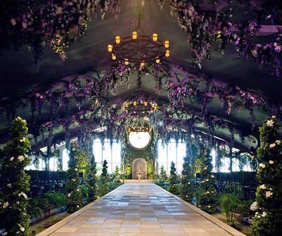 the inside of a building decorated with flowers and greenery