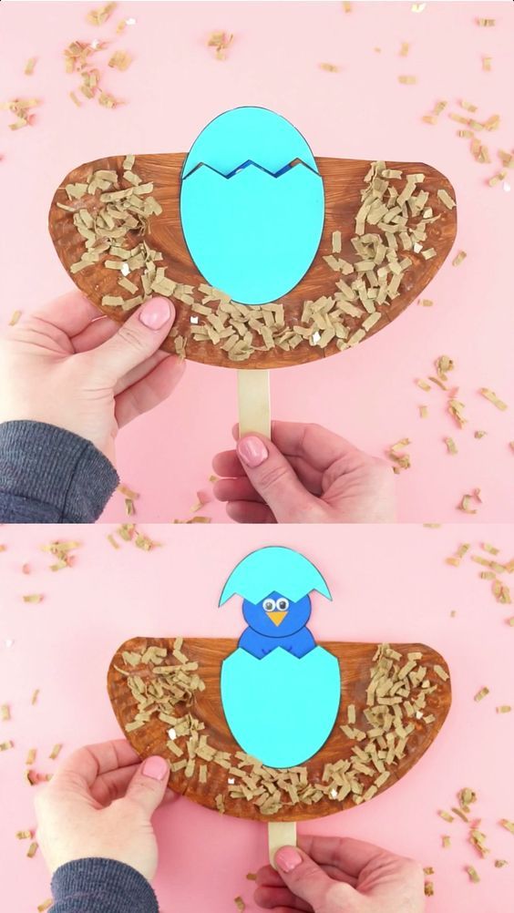 a hand holding a popsicle with an egg in the middle and cereal on top