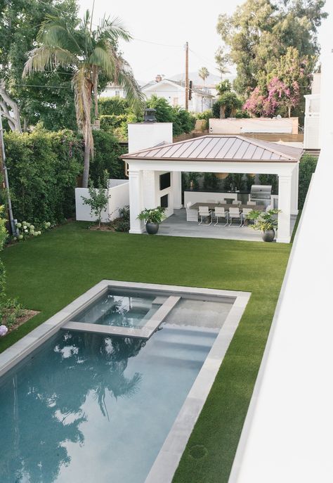 a backyard with a pool and patio furniture