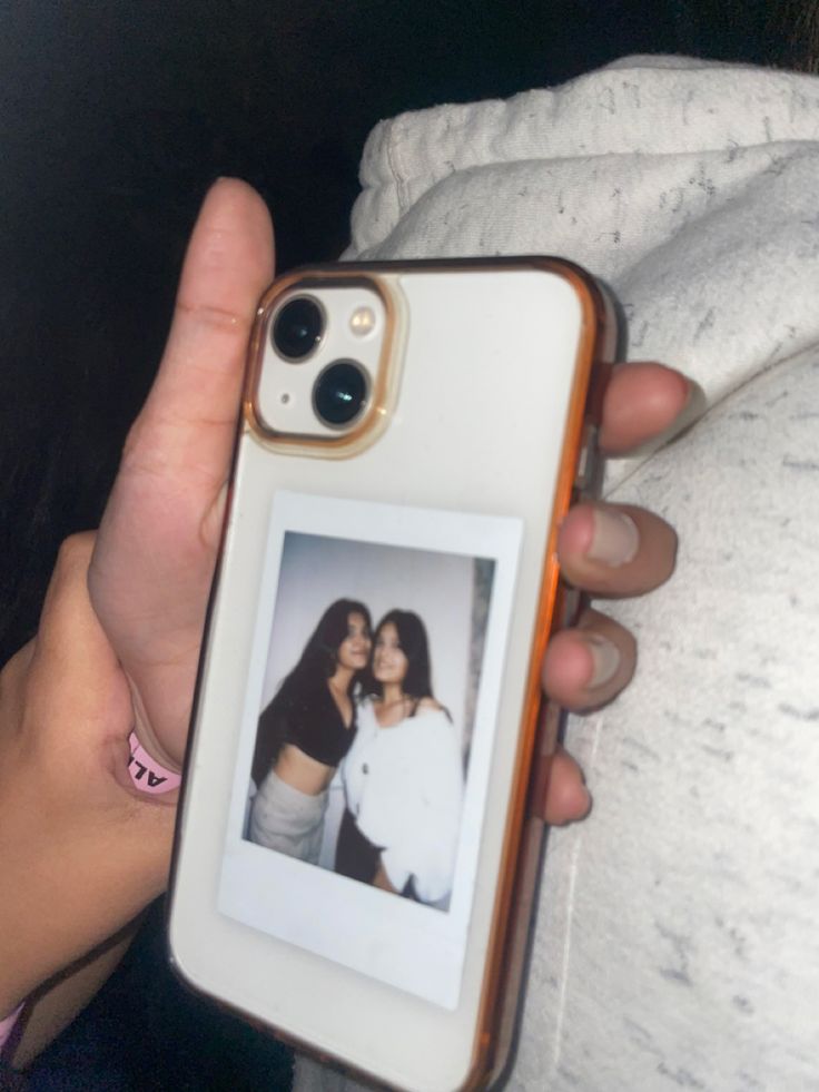 a person holding up a cell phone case with an image of two women on it