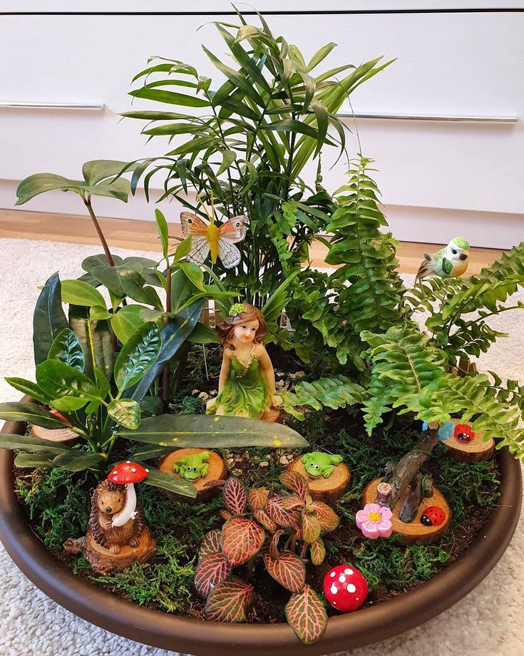 a planter filled with lots of plants and small figurines on top of it