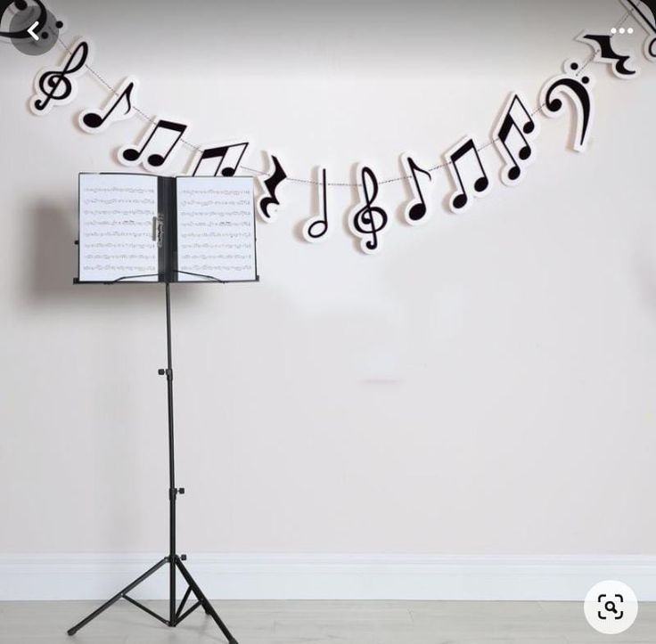 musical notes are hanging on the wall next to a music stand