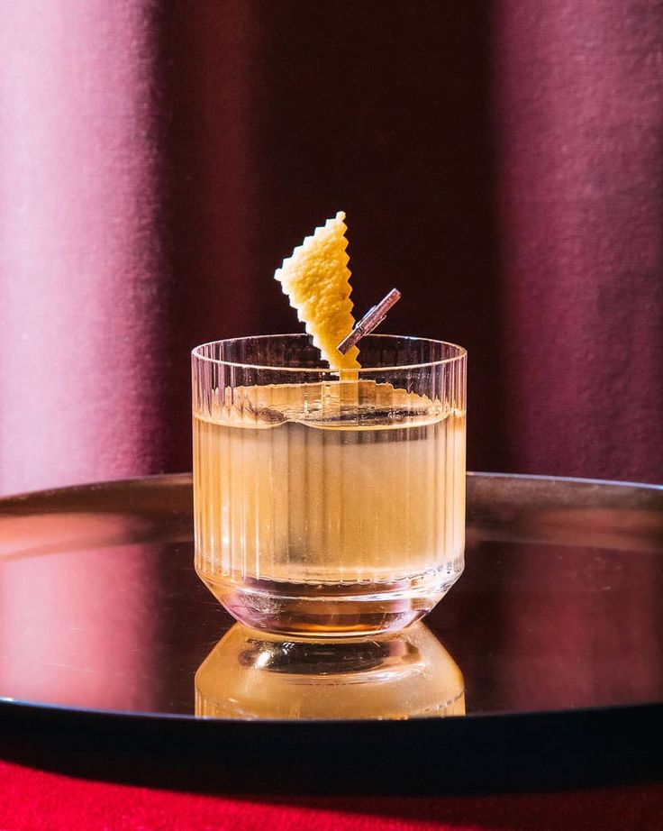 a glass filled with liquid and a small cracker sticking out of it's top