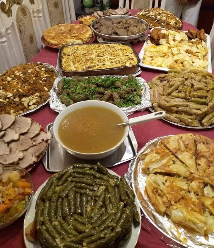 a table filled with lots of different types of food on plates and pans next to each other