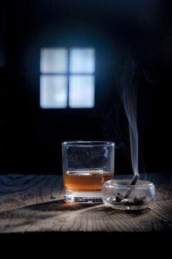 a glass filled with liquid sitting on top of a wooden table