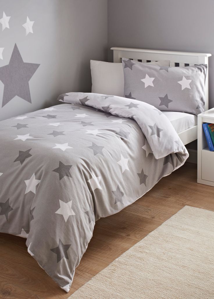 a child's bed with grey and white stars on it