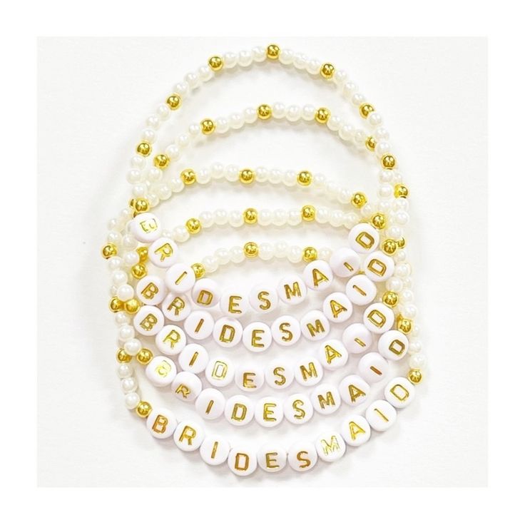 the bridesmaid bracelets are made with pearls and gold beaded letters on them