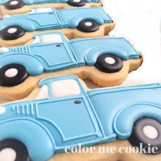 cookies decorated with blue and black cars are on a table