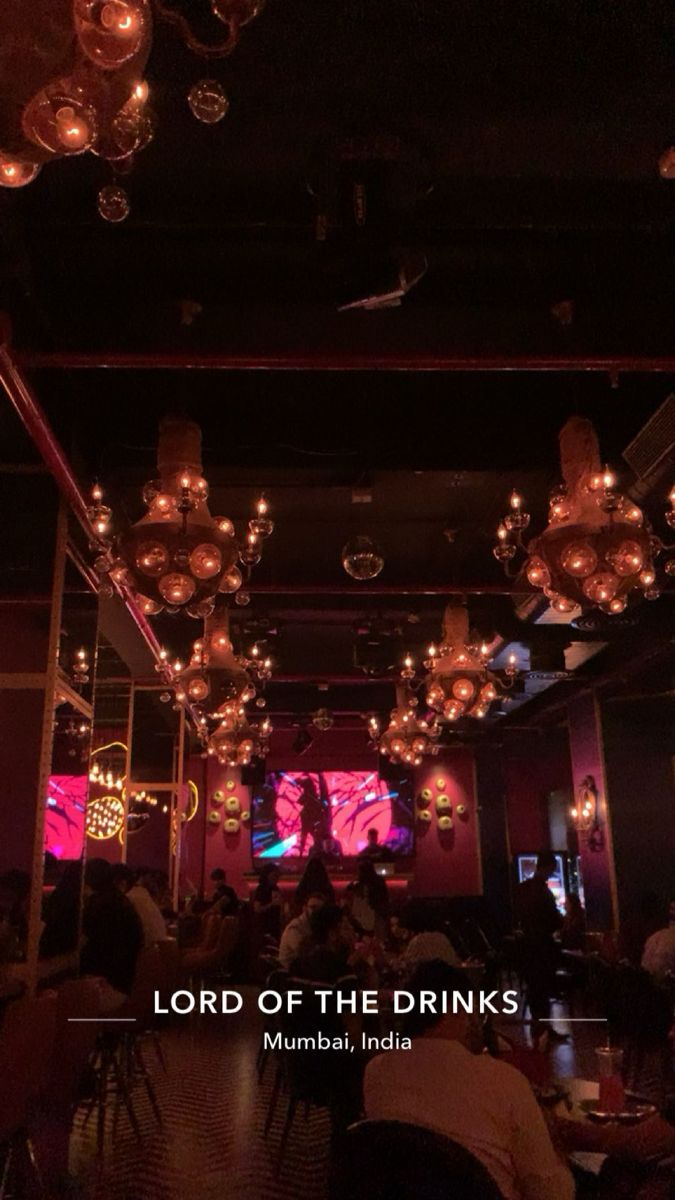 the inside of a restaurant with chandeliers hanging from the ceiling and people sitting at tables