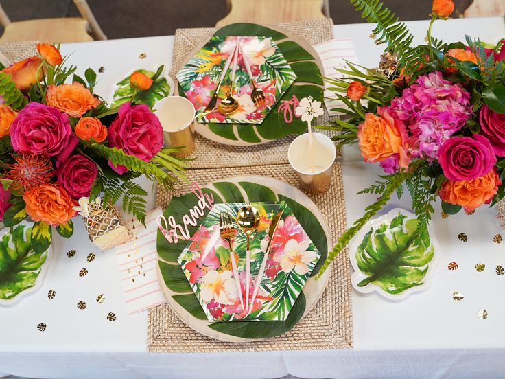 the table is decorated with tropical flowers and plates