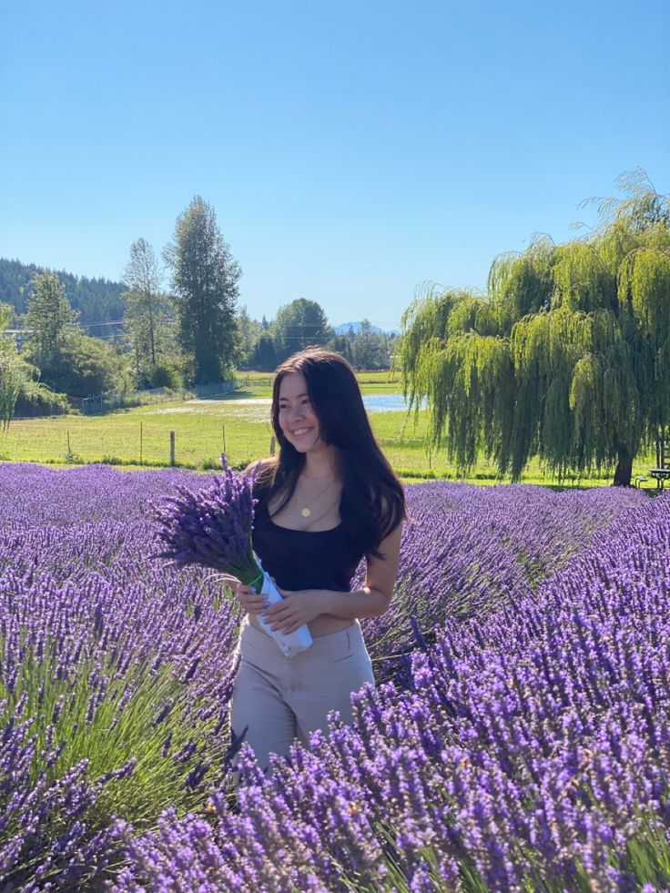 a woman standing in a field of lavender flowers