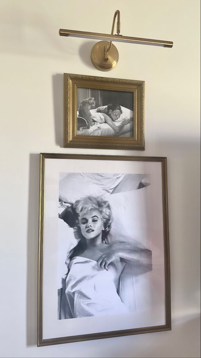 two framed pictures hang on the wall next to each other, one with a woman's face