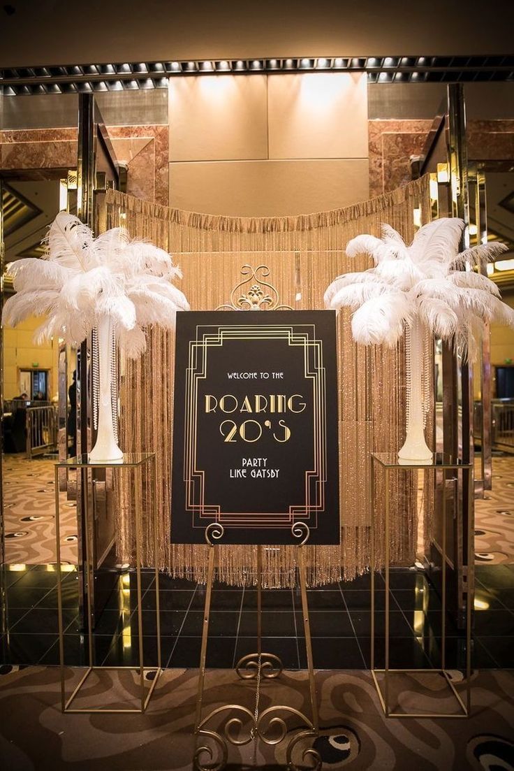 the entrance to an art deco event with tall white palm trees