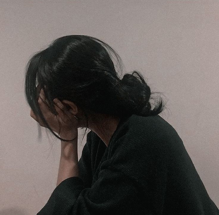 a woman sitting at a desk with her head in her hands