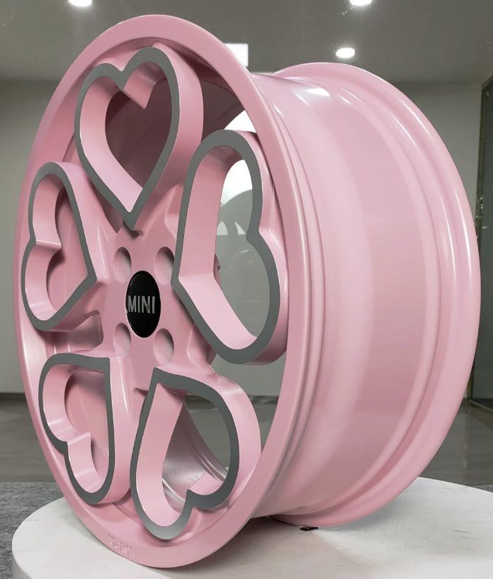 a pink wheel with hearts cut out of it on display in a showroom or office