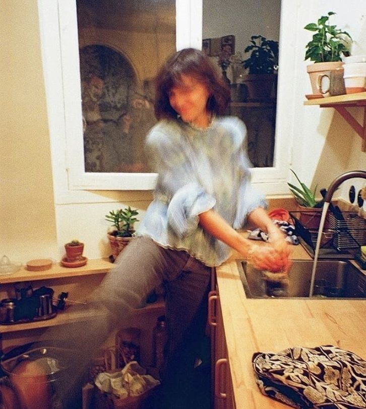 a woman standing in a kitchen next to a sink