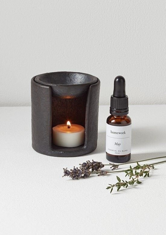 a bottle of essential oil next to a candle