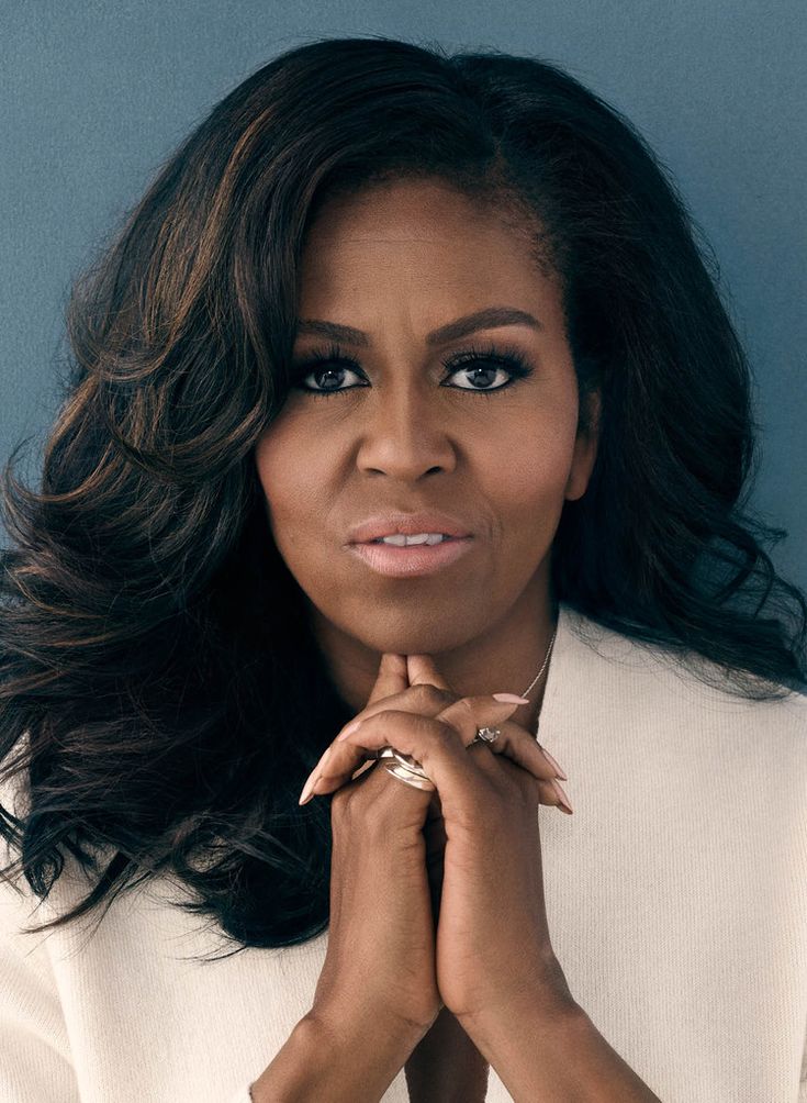 the first lady is posing with her hands on her chest and looking at the camera