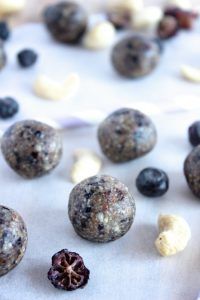 blueberries, raisins and nuts are scattered on a sheet of paper