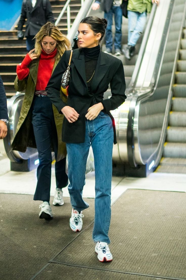 two women are walking down an escalator