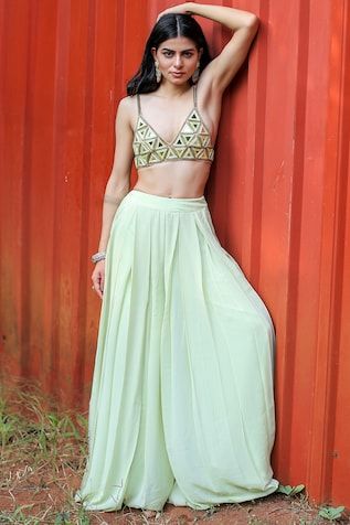 Mint green bralette featuring a sweetheart neckline and geometric mirror embroidery. Paired with a pleated cancan sharara for a complete look., Fit: Relaxed Green Sleeveless Lehenga For Summer, Pista Green Summer Party Sets, Summer Party Sets In Pista Green, Green Bohemian Summer Choli, Bohemian Green Sharara For Summer, Summer Bohemian Green Sharara, Green Sharara For Summer Party, Bohemian Fitted Sharara For Summer, Fitted Summer Sets With Mirror Work