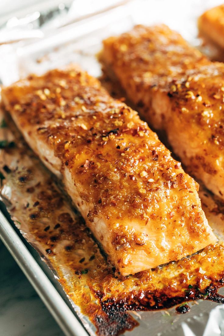 two pieces of cooked fish sitting on top of tin foil