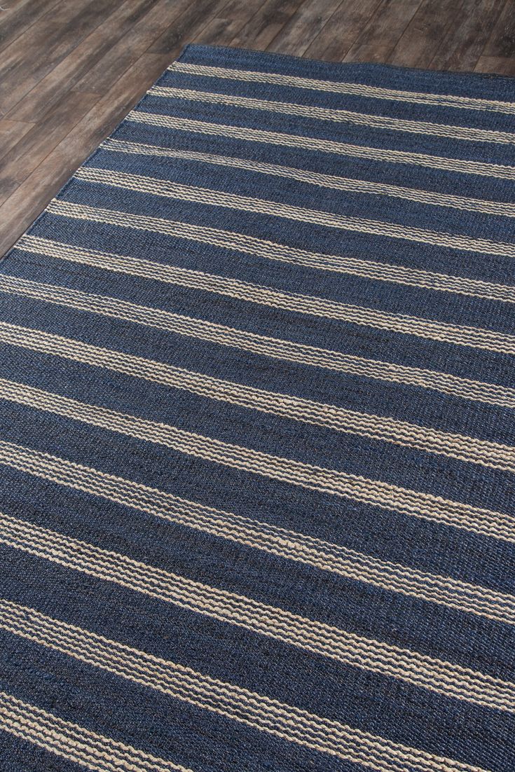 a blue and white striped rug sitting on top of a wooden floor