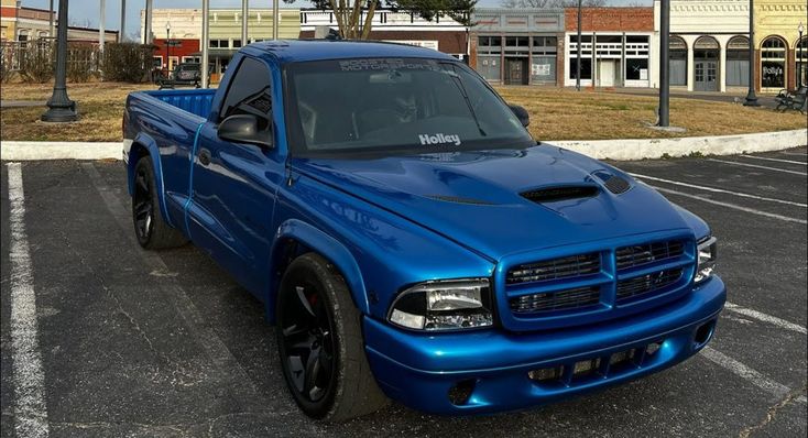 a blue dodge truck parked in a parking lot