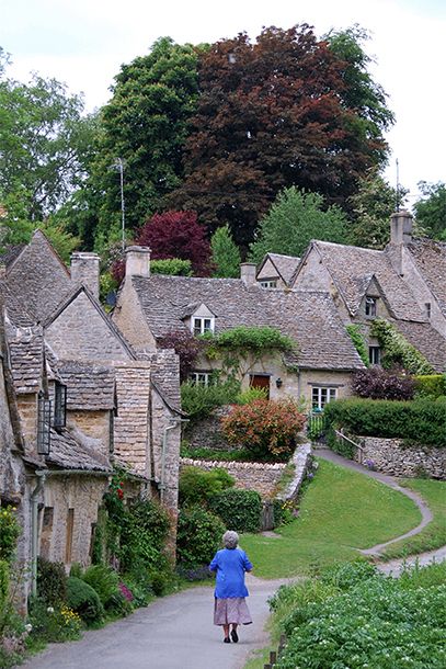 a woman walking down a path in an old village