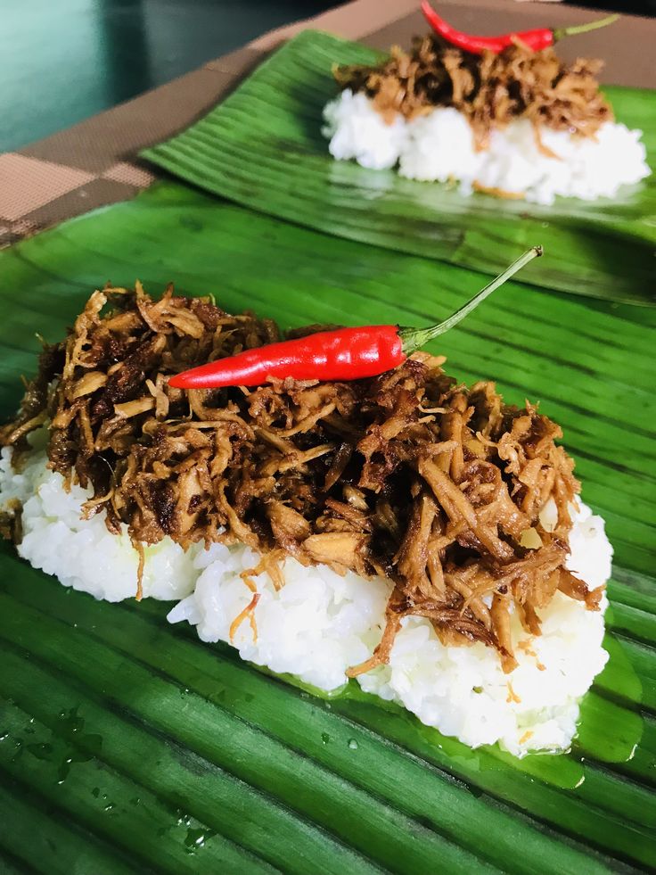 some food is sitting on top of a banana leaf