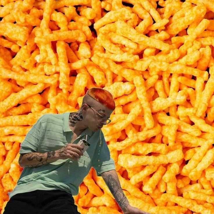 a man standing in front of a giant pile of cheetos with his mouth open