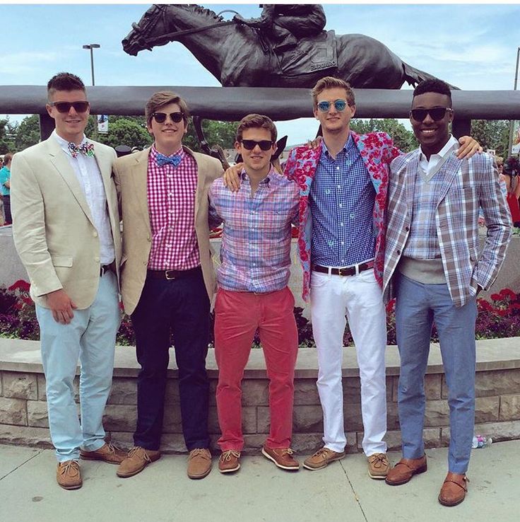 four men standing next to each other in front of a horse statue with sunglasses on