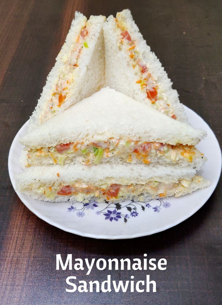 a sandwich cut in half sitting on top of a white plate with the words mayonnaise sandwich