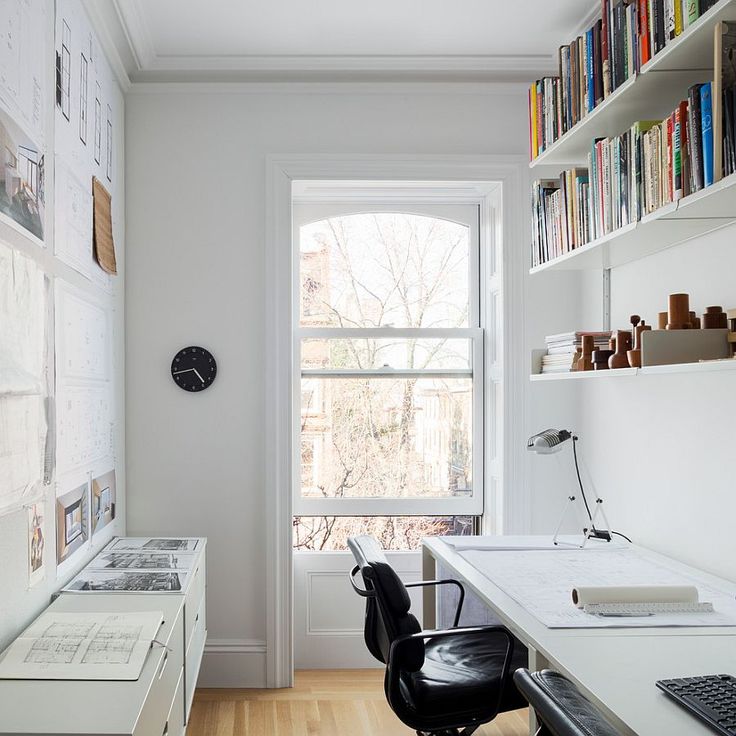 a home office with bookshelves, desk and computer on the far wall in front of a window