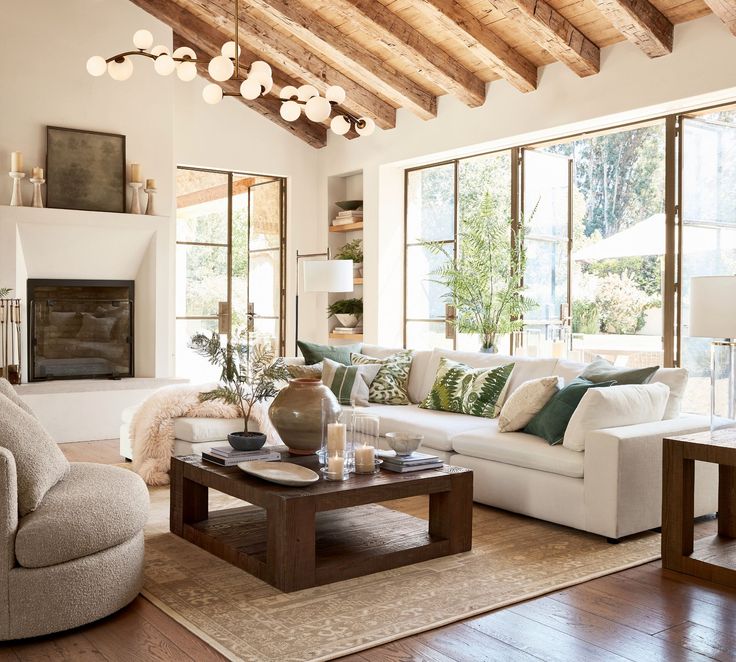 a living room filled with lots of furniture next to a fire place and large windows