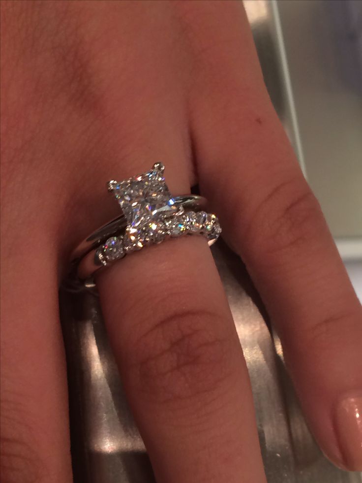 a close up of a person's hand with a diamond ring