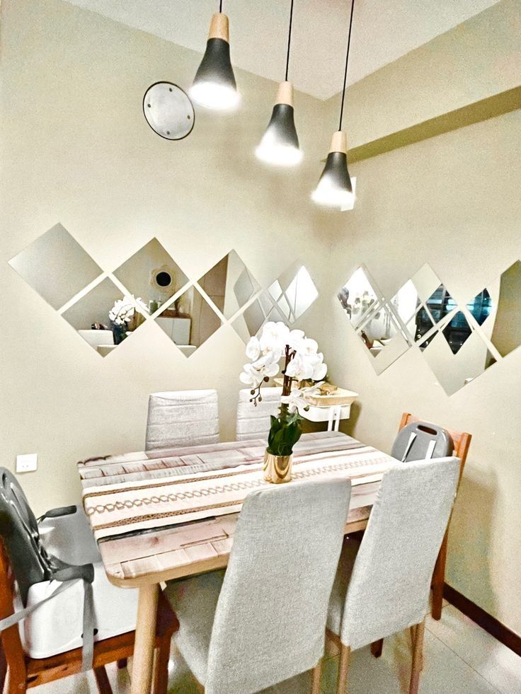 a dining room table with four chairs and a vase filled with flowers on top of it