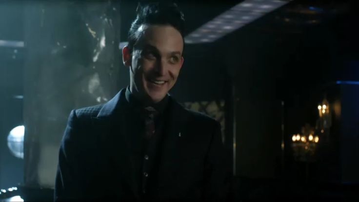 a man in a suit and tie smiling at the camera