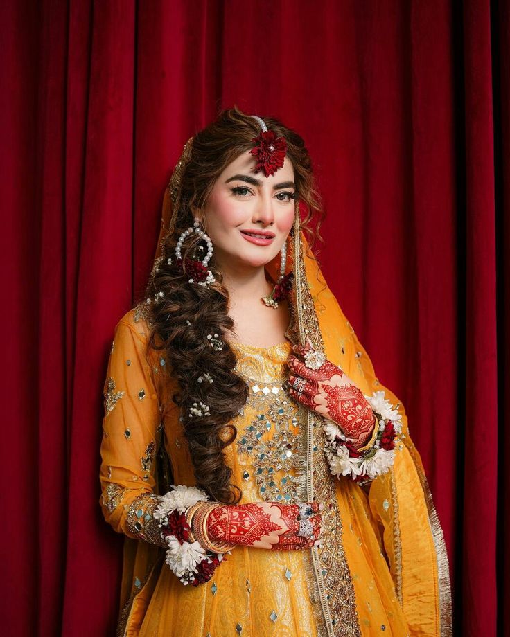 a woman dressed in yellow and red poses for the camera